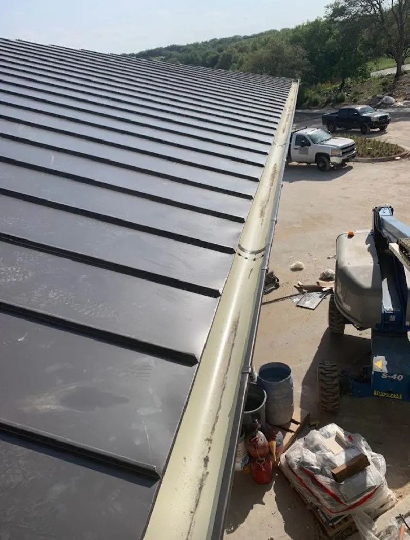 Standing seam panel and gutter detail on a metal roofing jobsite in Meriden